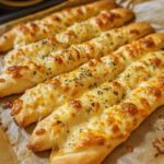 Freshly baked cheesy garlic breadsticks with melted cheese and parsley