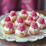 A plate of Raspberry Cream Cheese Bites with fresh raspberries on top