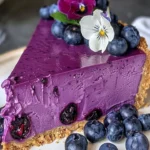 A slice of luxurious no-bake blueberry cheesecake topped with fresh blueberries