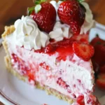 A delicious slice of frozen strawberry cheesecake with fresh strawberries on top.