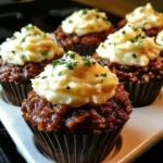 A plate of Meatloaf Cupcakes topped with fluffy mashed potatoes, garnished with parsley.