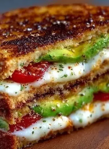 Avocado, mozzarella, and tomato grilled cheese sandwich on a plate
