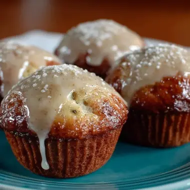 Freshly baked donut muffins topped with glaze and sprinkles